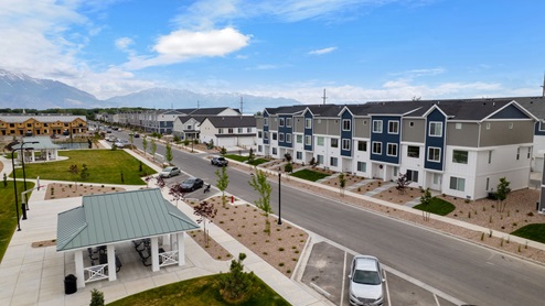 Beautiful aerial photo of the Northshore community by D.R. Horton of townhomes, community monument, clubhouse and pool and surrounding mountains and Utah Lake.