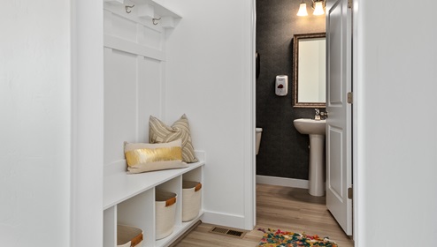 A smart and organized mudroom with built ins that then leads into a conveniently placed powder room on the main floor.