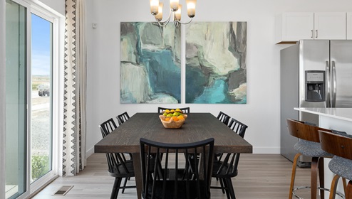 Connected by open space and kitchen adjacent is the spacious dining area where a 6 seat table is present and a stylish hanging light and sliding glass door to the patio.