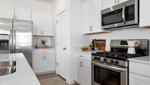 A view of the kitchen with all of it’s open counterspace, stainless steel appliances and spacious pantry.