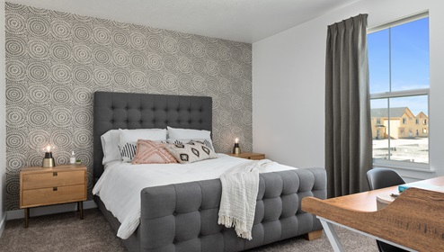Large secondary bedroom big enough for a large bed, two side tables, a writing desk and a large window.