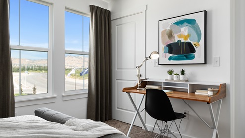View of the same secondary bedroom with the large windows, closet and writing desk.