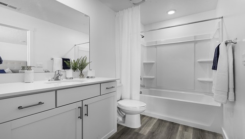Primary bathroom with white cabinets and countertops and shower surround.