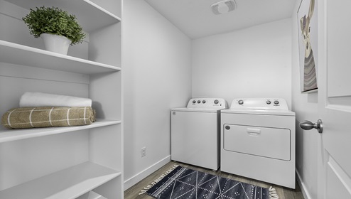 Spacious laundry room with shelving.