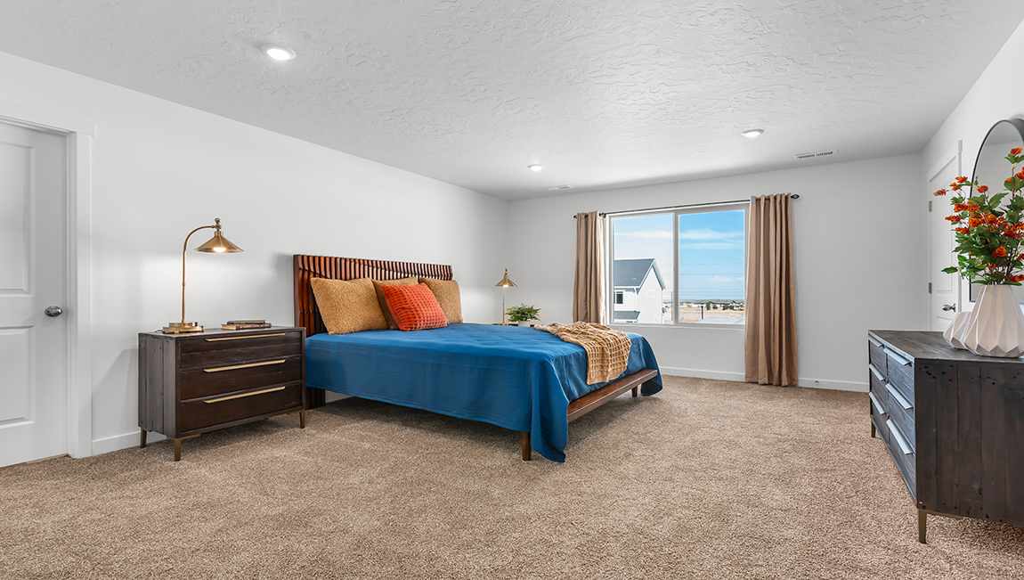 Spacious primary bedroom with a large window.