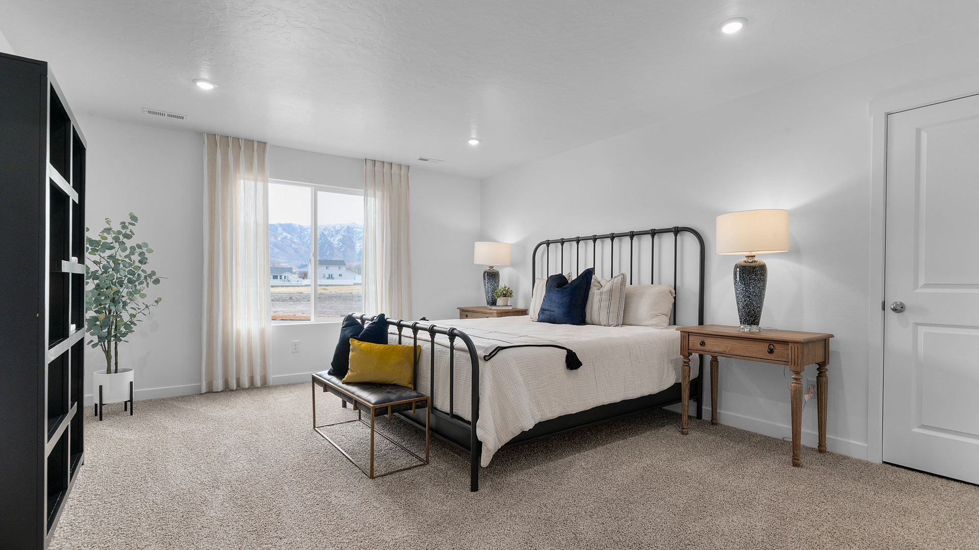 Spacious primary bedroom with a large window.