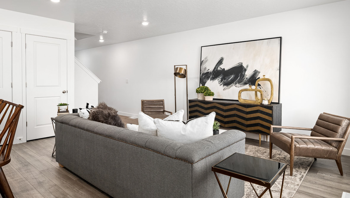 View of the living room from the corner of the dining area with a peek into the hallway entrance into the home.