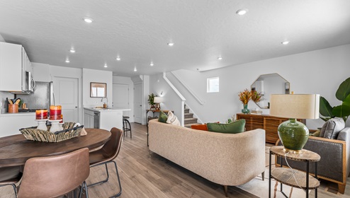 Open concept main floor layout at the Western Acres Townhome community in Tooele Utah that includes living room, dining area and kitchen in a nice open space with a kitchen peninsula that adds a ton of counterspace.