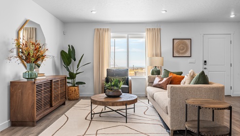Spacious living room area with large window on the main floor of an open concept townhome in the D.R. Horton Western Acres community.