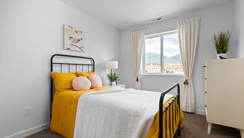 Secondary bedroom with large window in a townhome floor plan in Western Acres by D.R. Horton.