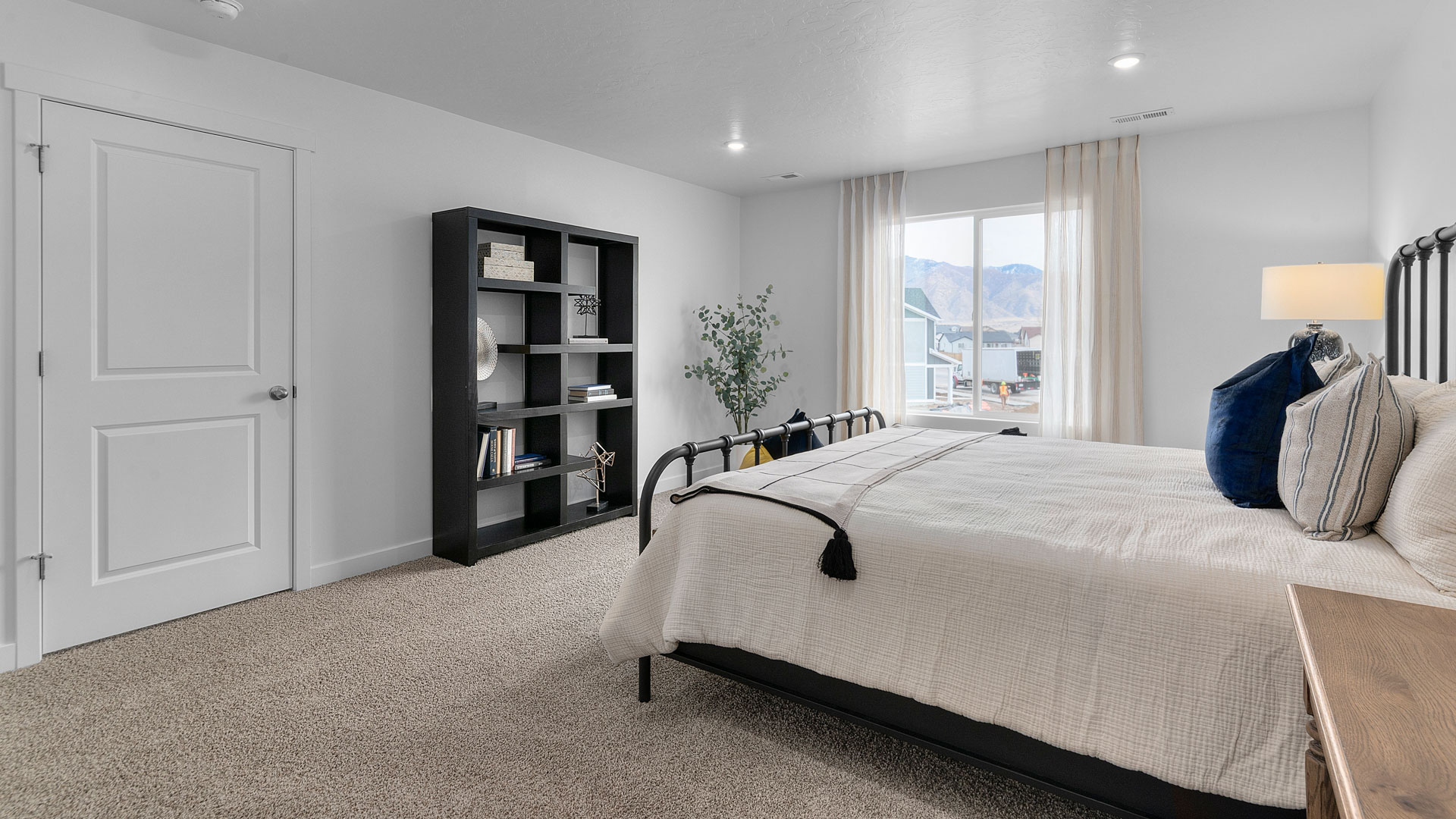 Spacious primary bedroom with a large window.