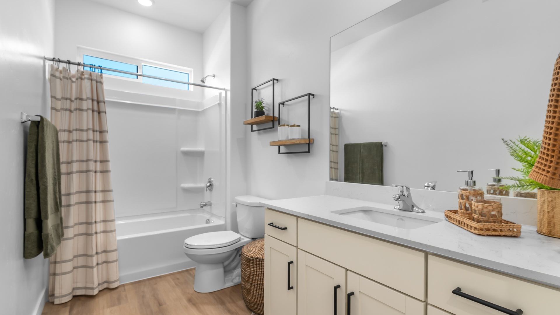 Full-size bathroom with light grey cabinets and white shower tub surround.