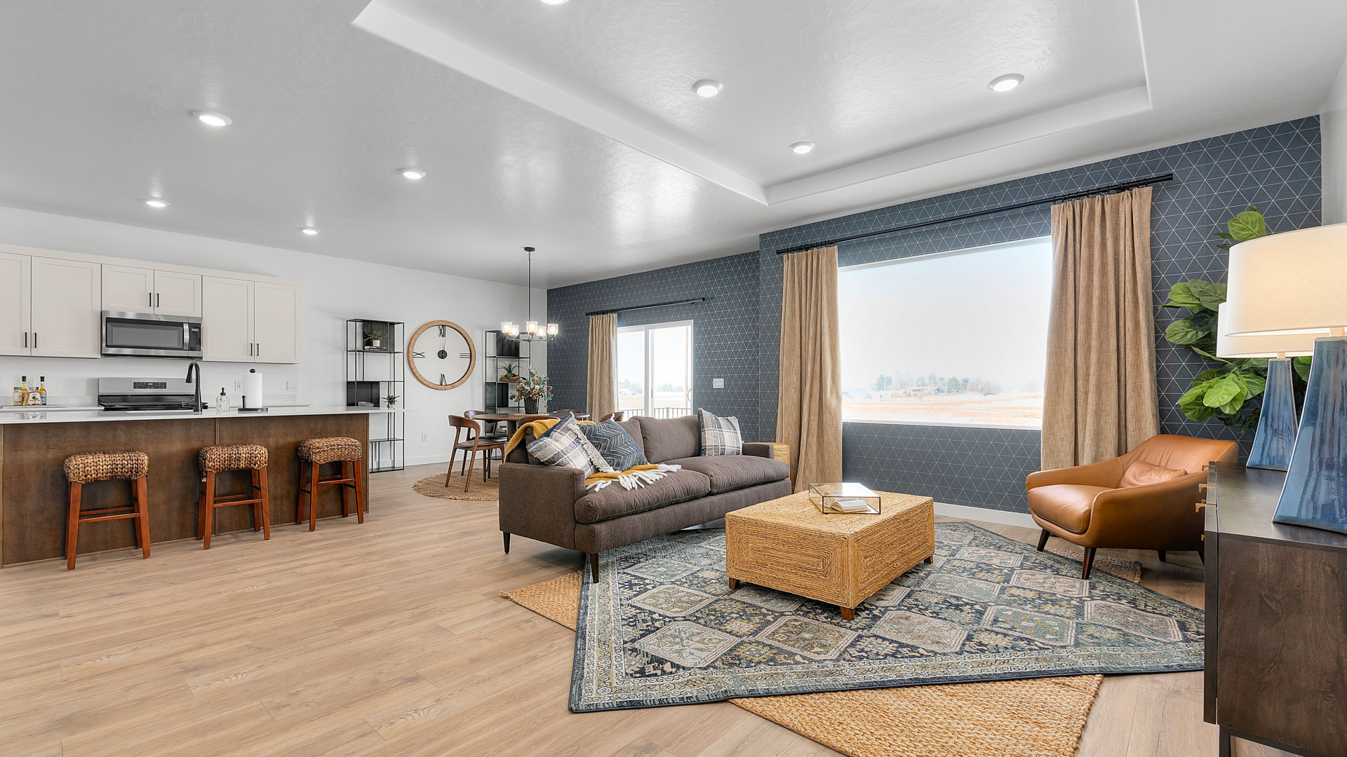 Living room with large window and recessed ceiling with canned lights.