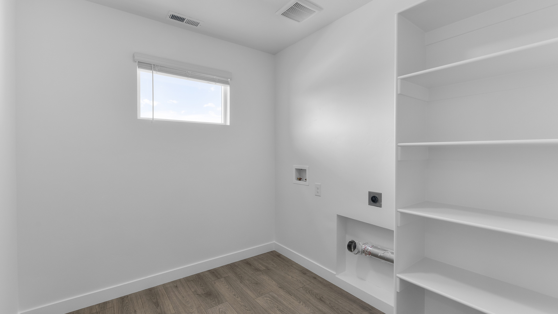 Laundry room with shelving and window.