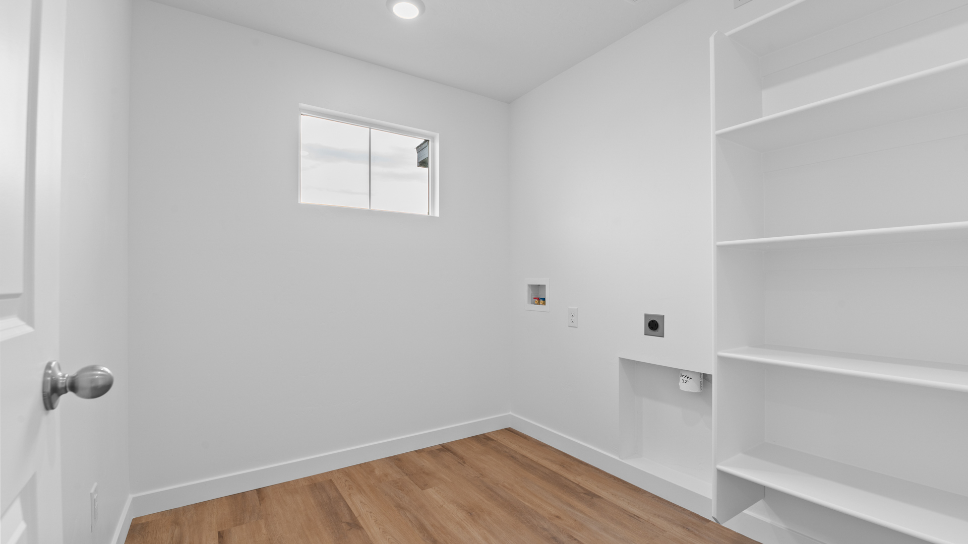 Laundry room with shelving and window.