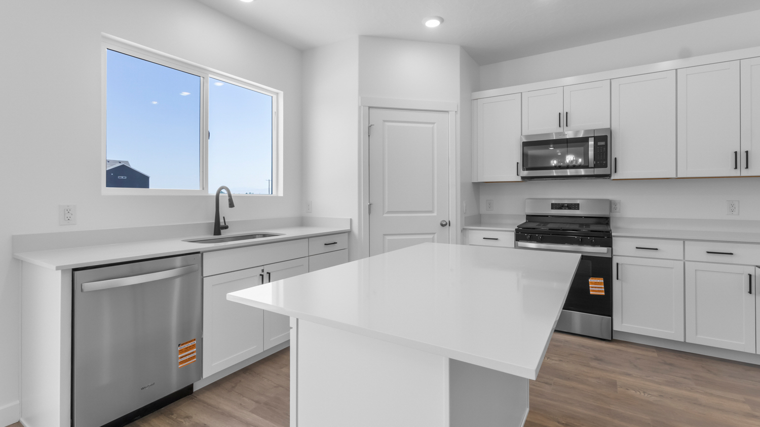 Kitchen with kitchen island and stainless steel appliances.