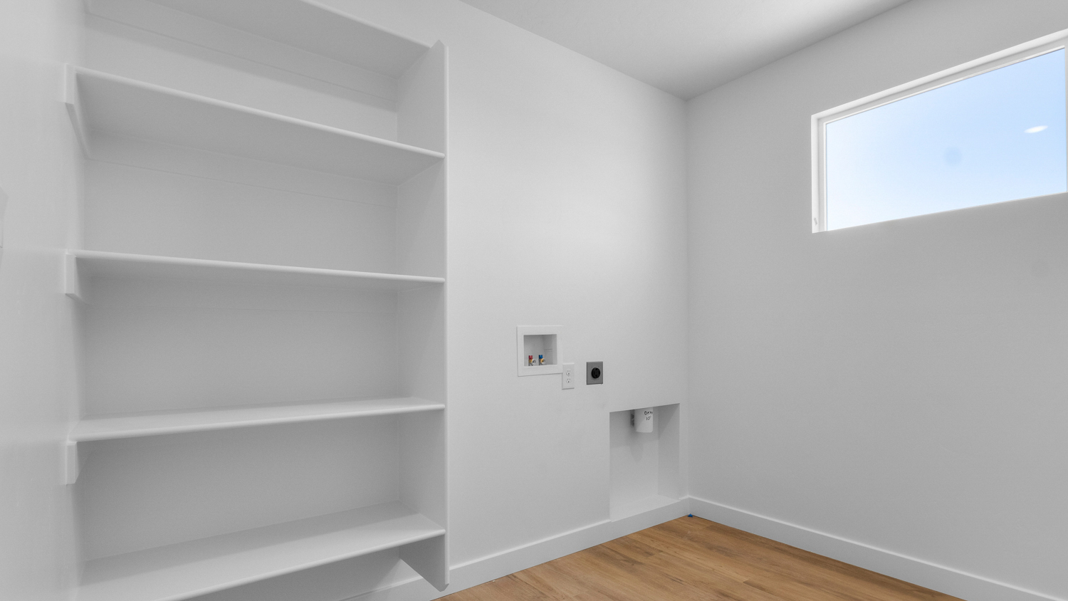 Laundry room with selving and window.