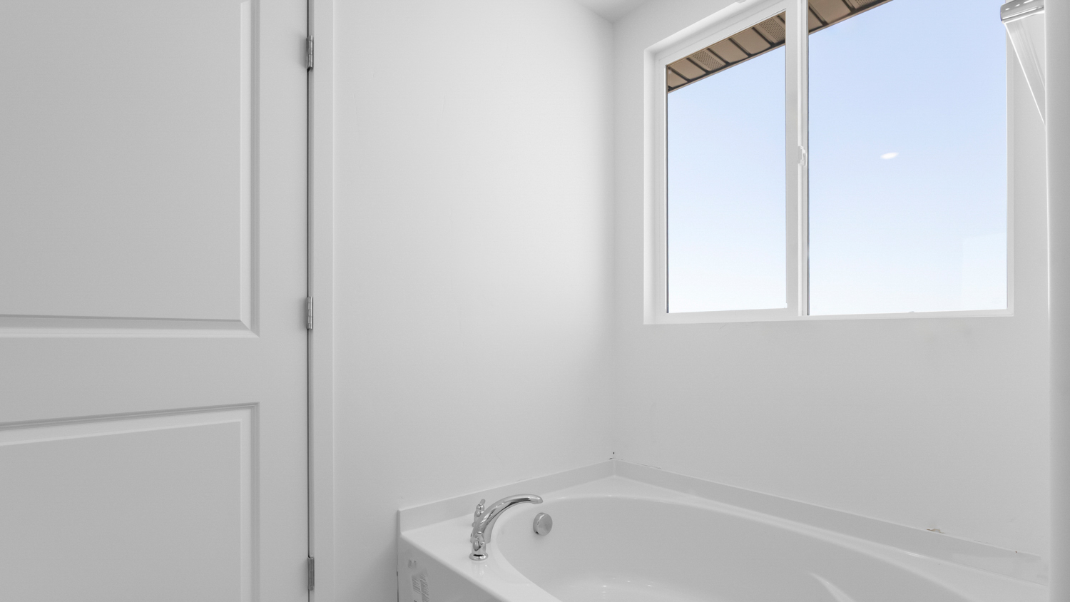 Primary bathroom with tub and window.