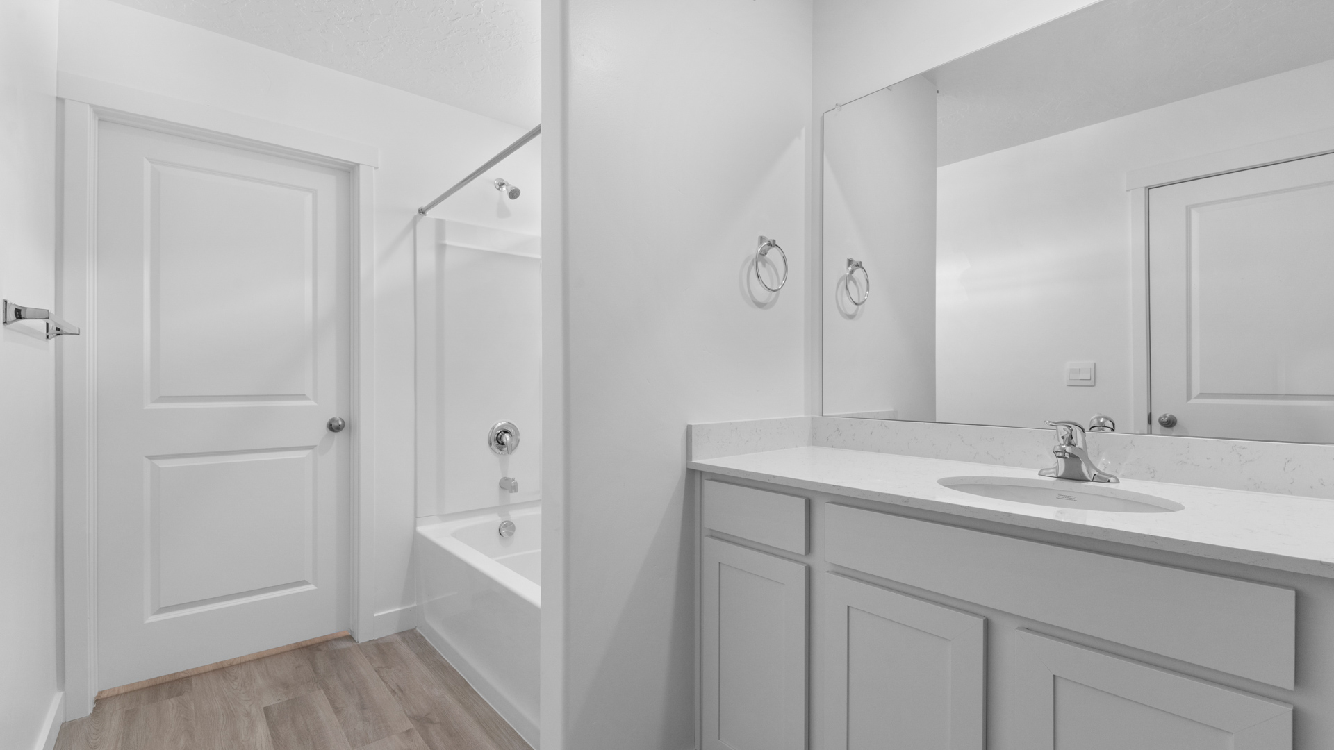 Primary bathroom with vanity and shower surround.