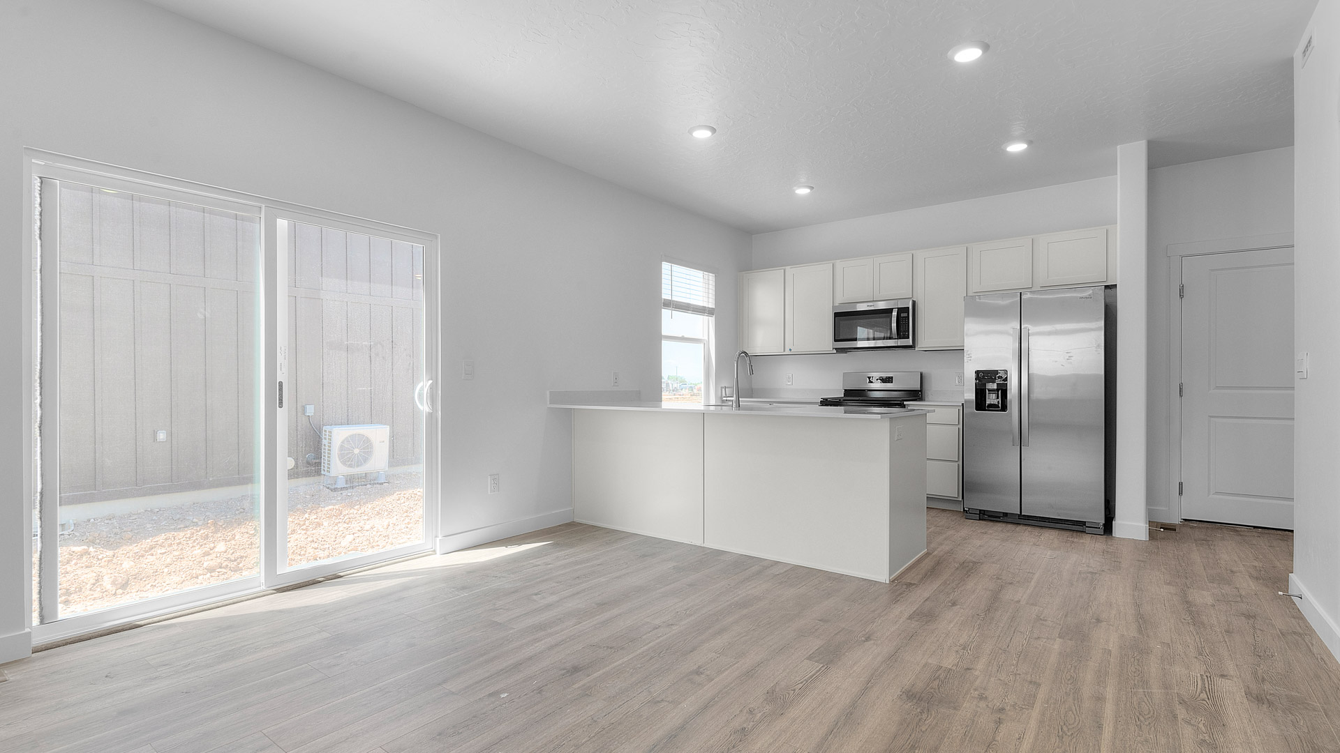 Dining room and kitchen space with stainless steel appliances.