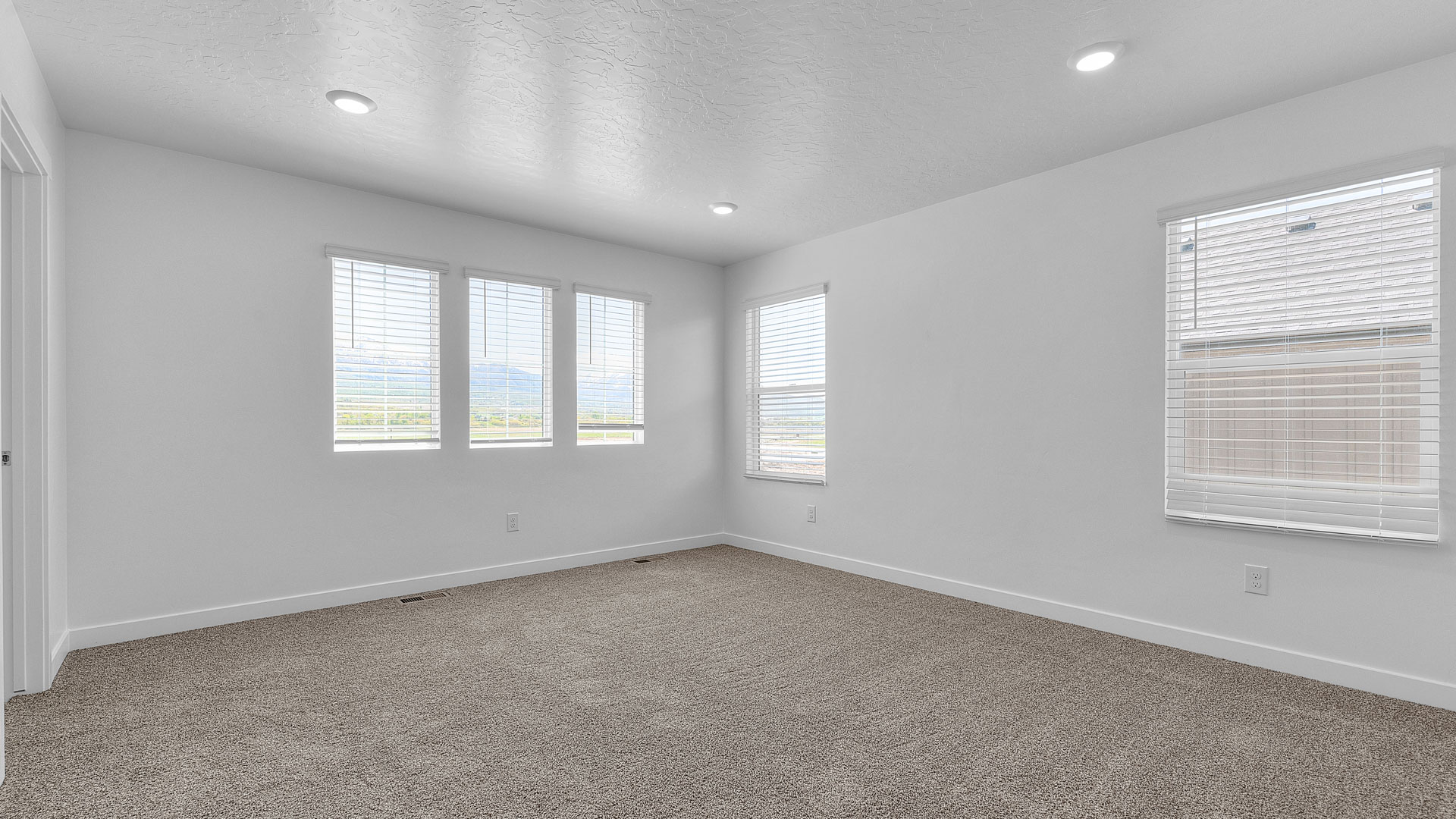 Spacious primary room with windows.