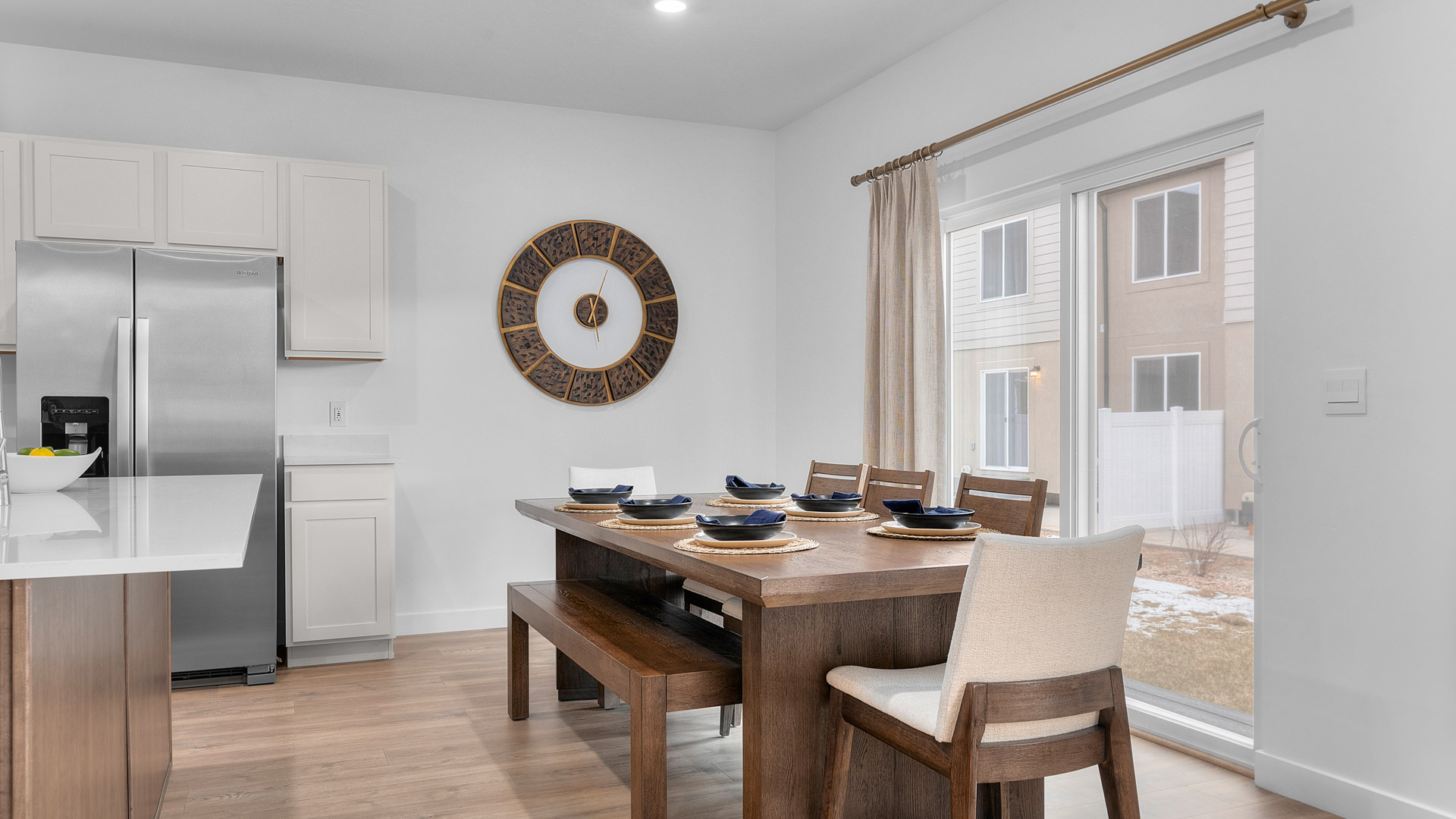 Focusing on the dining area where there is room for a 6 seat dining table including a stylish hanging light over the dining table and sliding glass doors leading to the back patio.