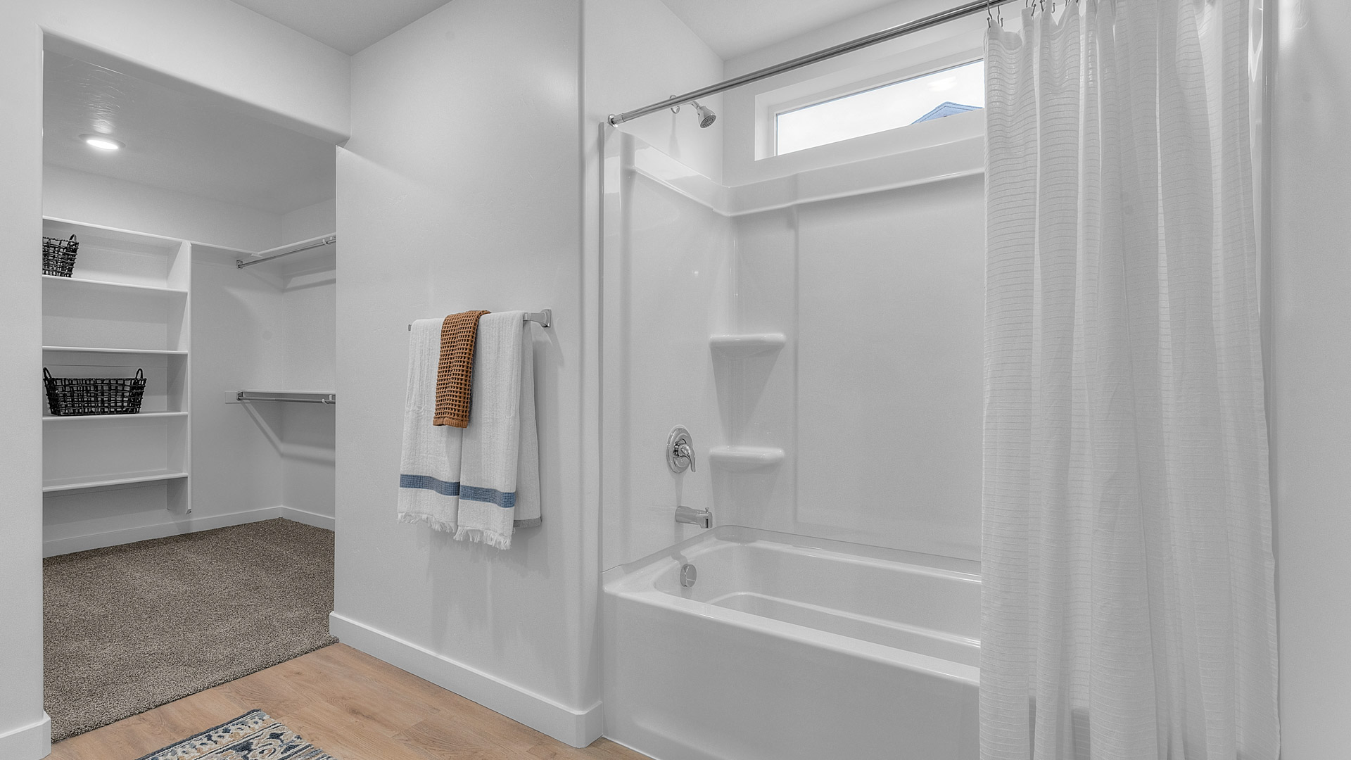 Primary bedroom tub shower combination with window above.