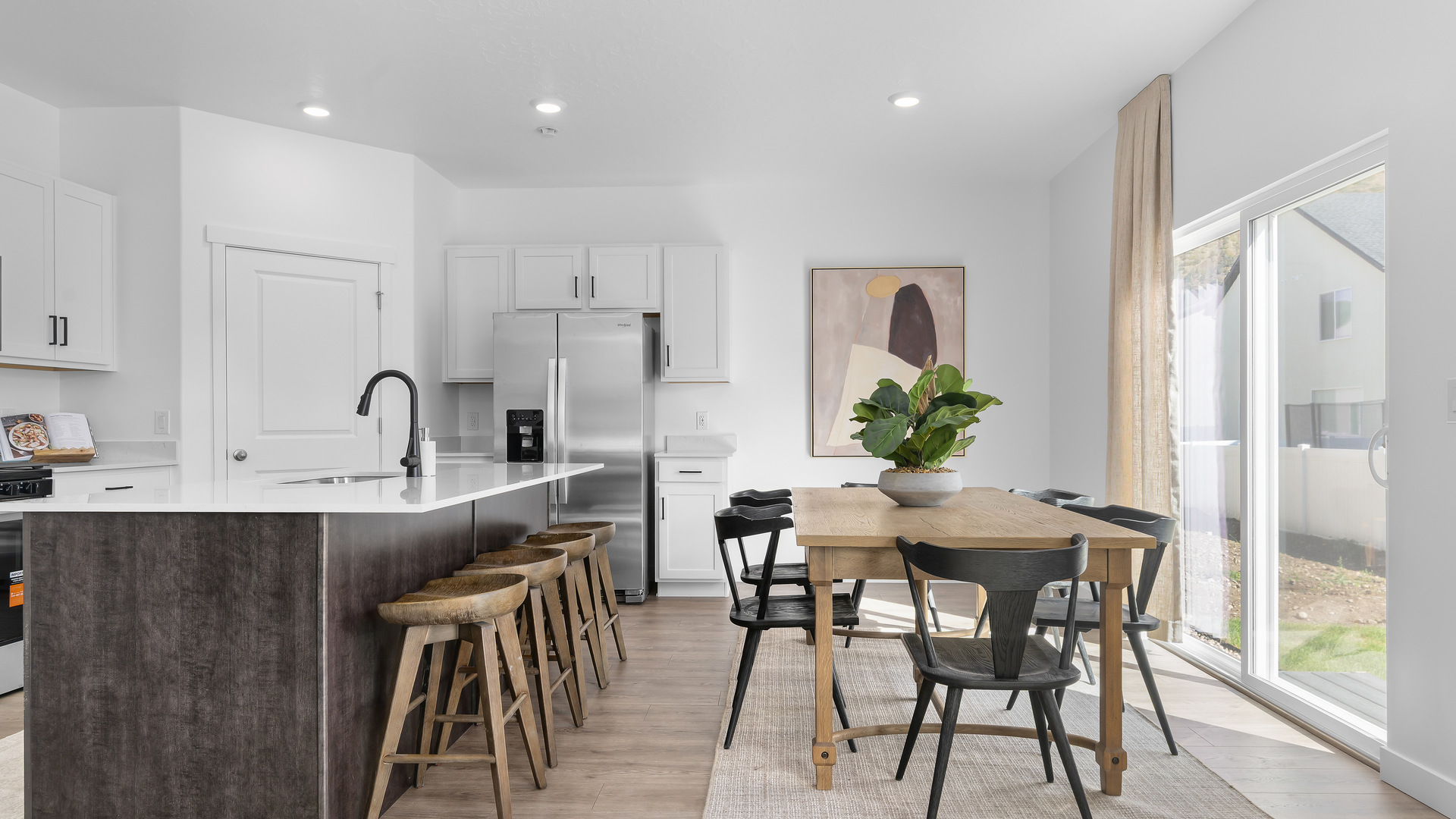 Focusing on the dining area where there is room for a 6 seat dining table including a stylish hanging light over the dining table and sliding glass doors leading to the back patio.