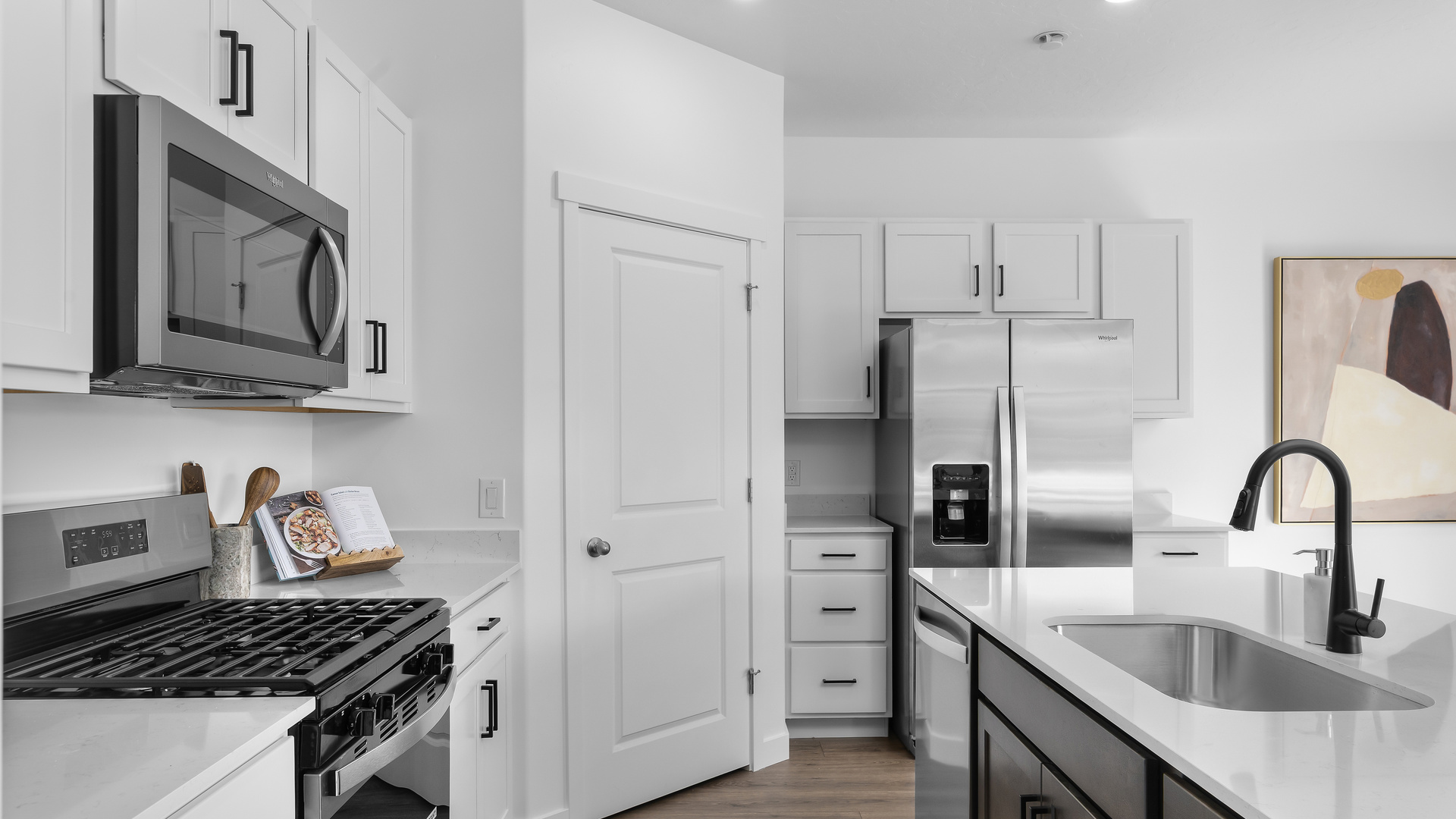 Spacious kitchen with kitchen island and sink, cabinets, and stainless steel appliances.