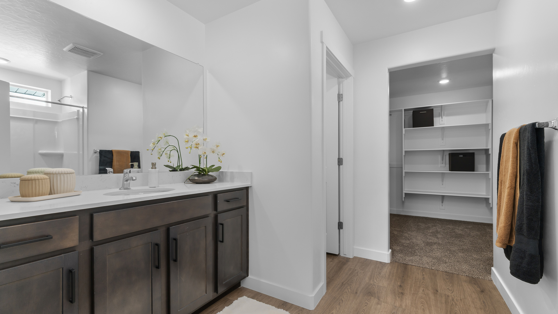 Primary bathroom with vanity and shower surround.