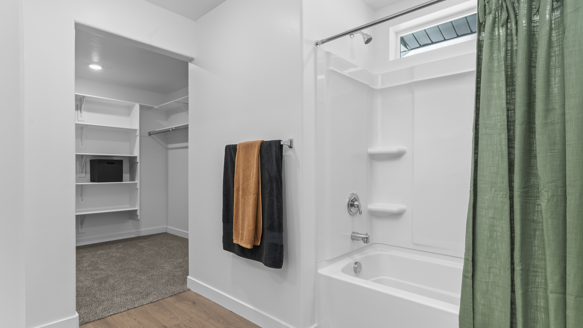 Primary bathroom with vanity and shower surround.