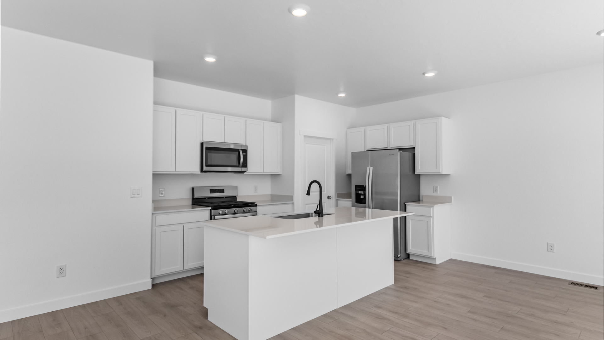 Kitchen space with kitchen island and stainless steel appliances.