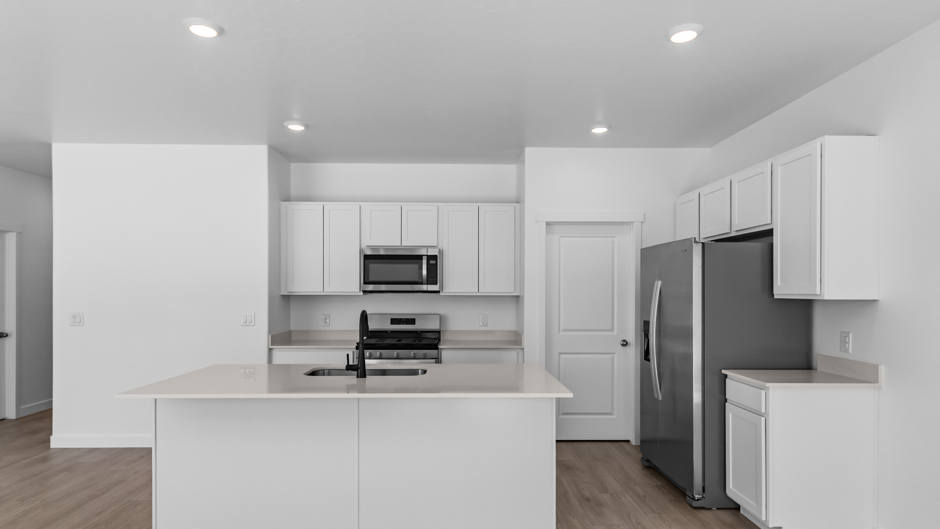 Kitchen space with kitchen island and stainless steel appliances.