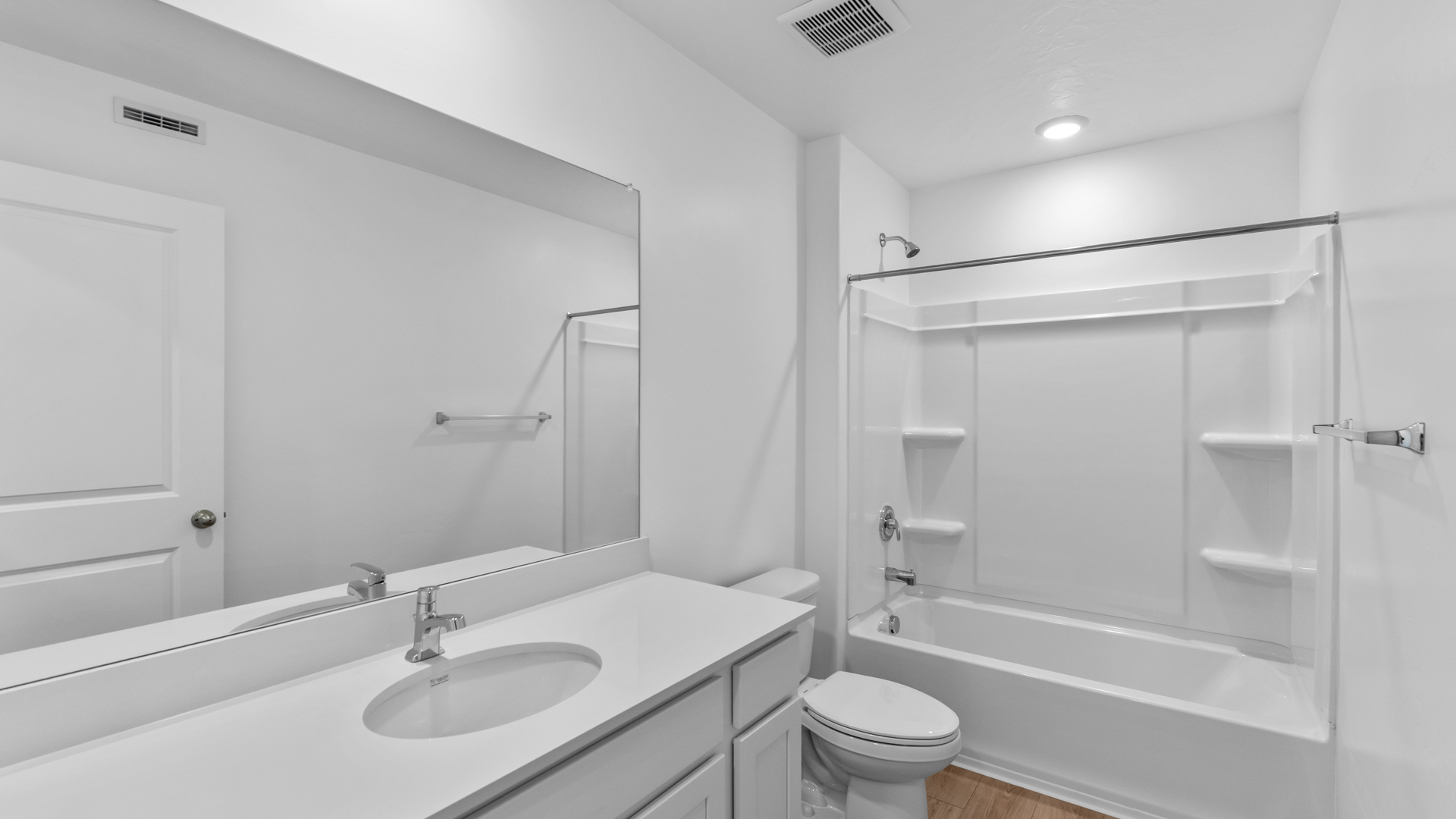 Bathroom with large vanity and shower surround.