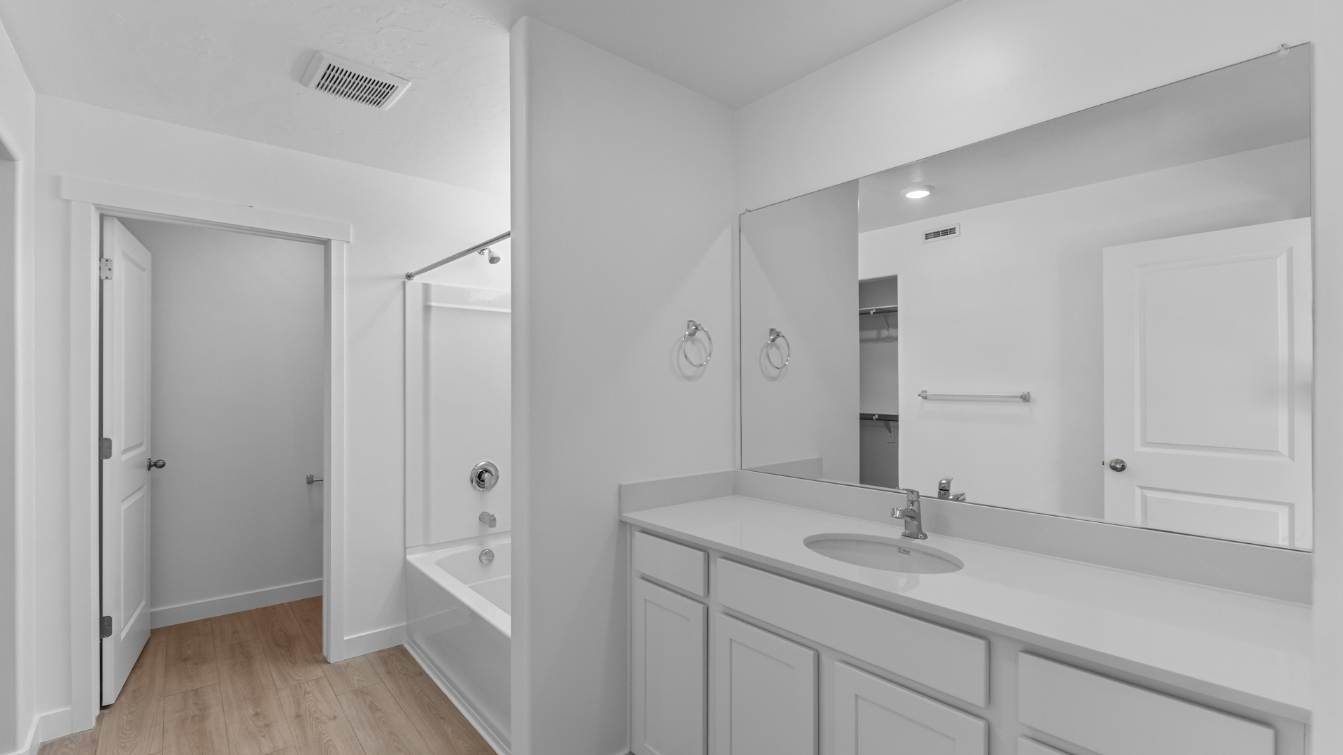 Primary bathroom with large vanity and shower surround.