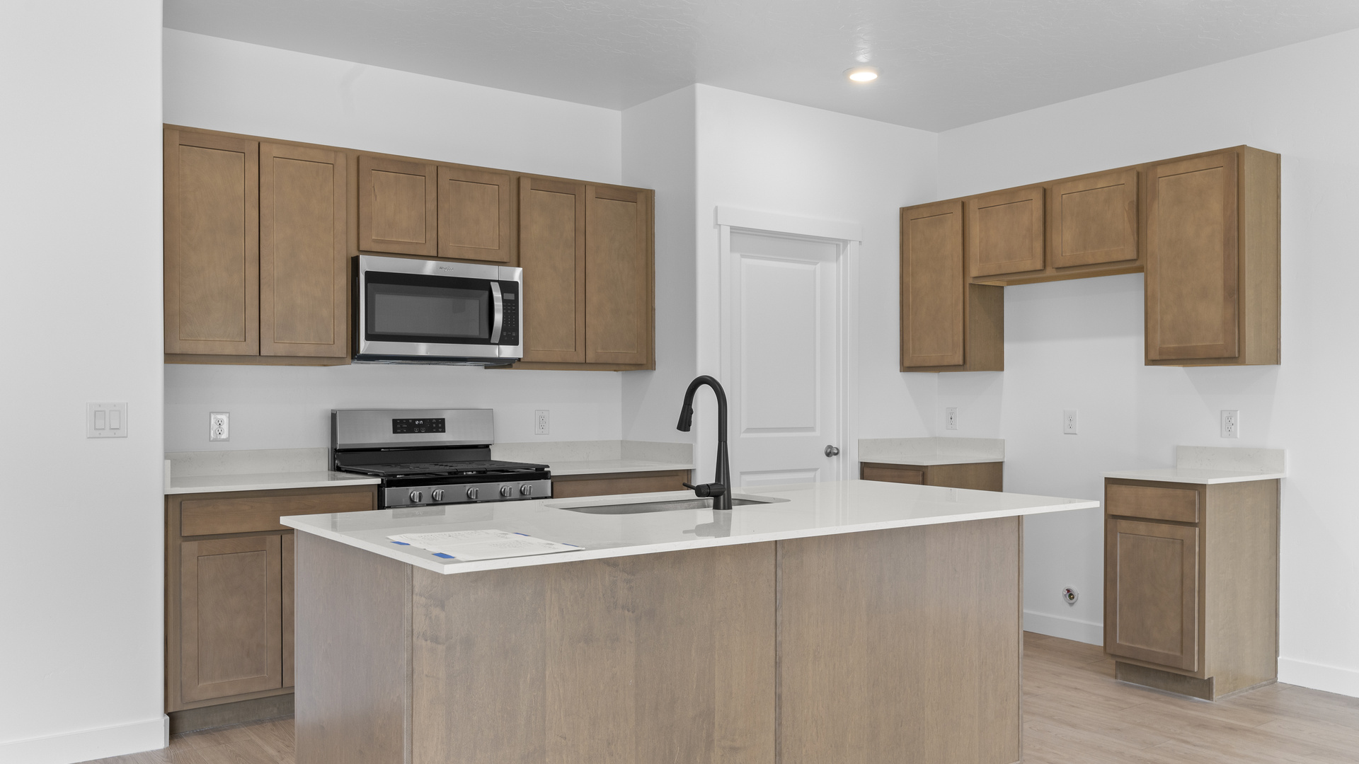 Kitchen space with kitchen island and stainless steel appliances.