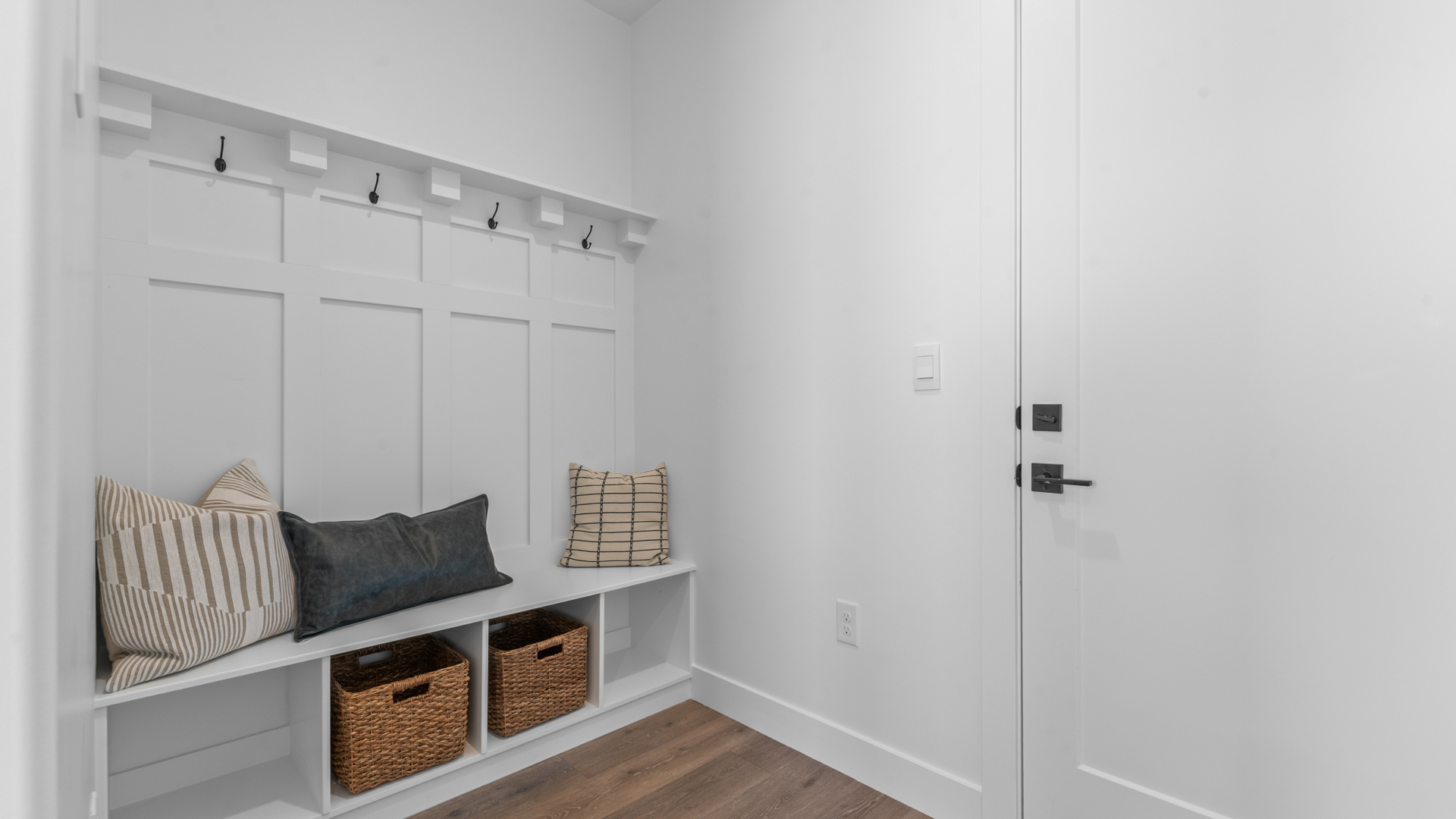 Mudroom off garage with storage shelves and bench.