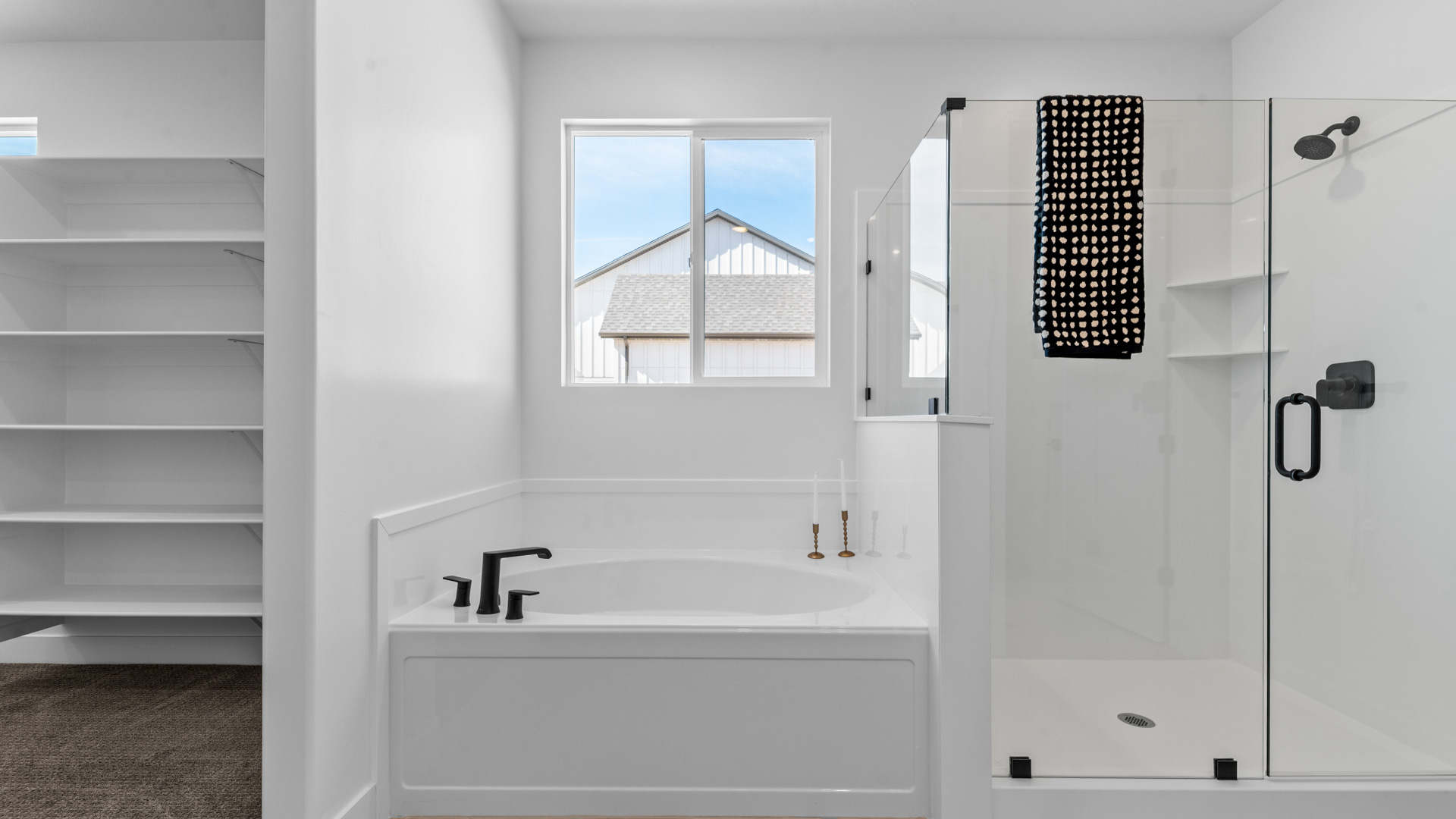 Primary bathroom with double sink vanity, soaking tub, and glass shower.