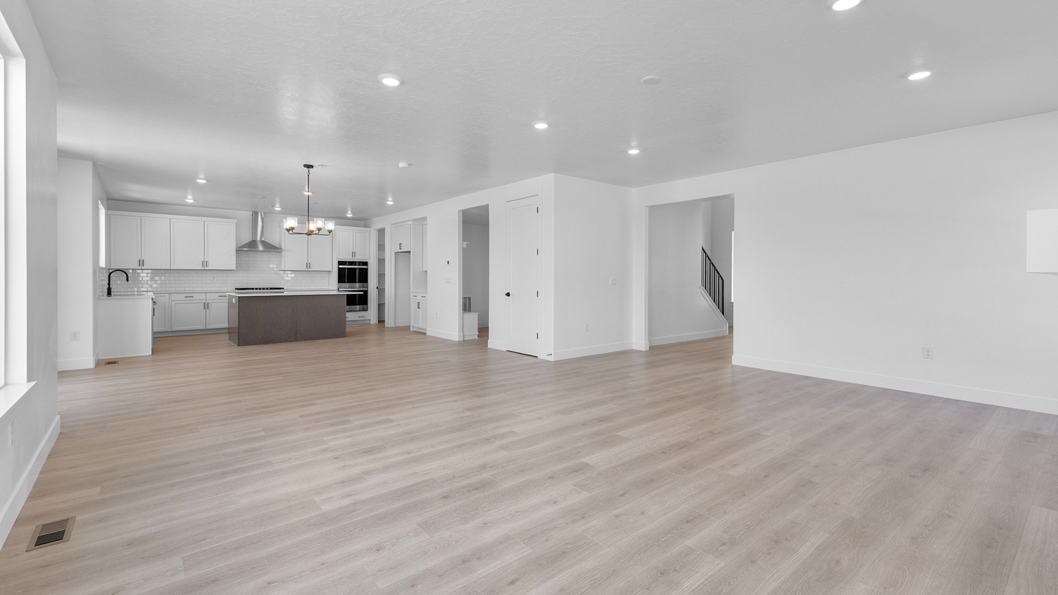 Family room, dining, and kitchen,  with fireplace and large windows.