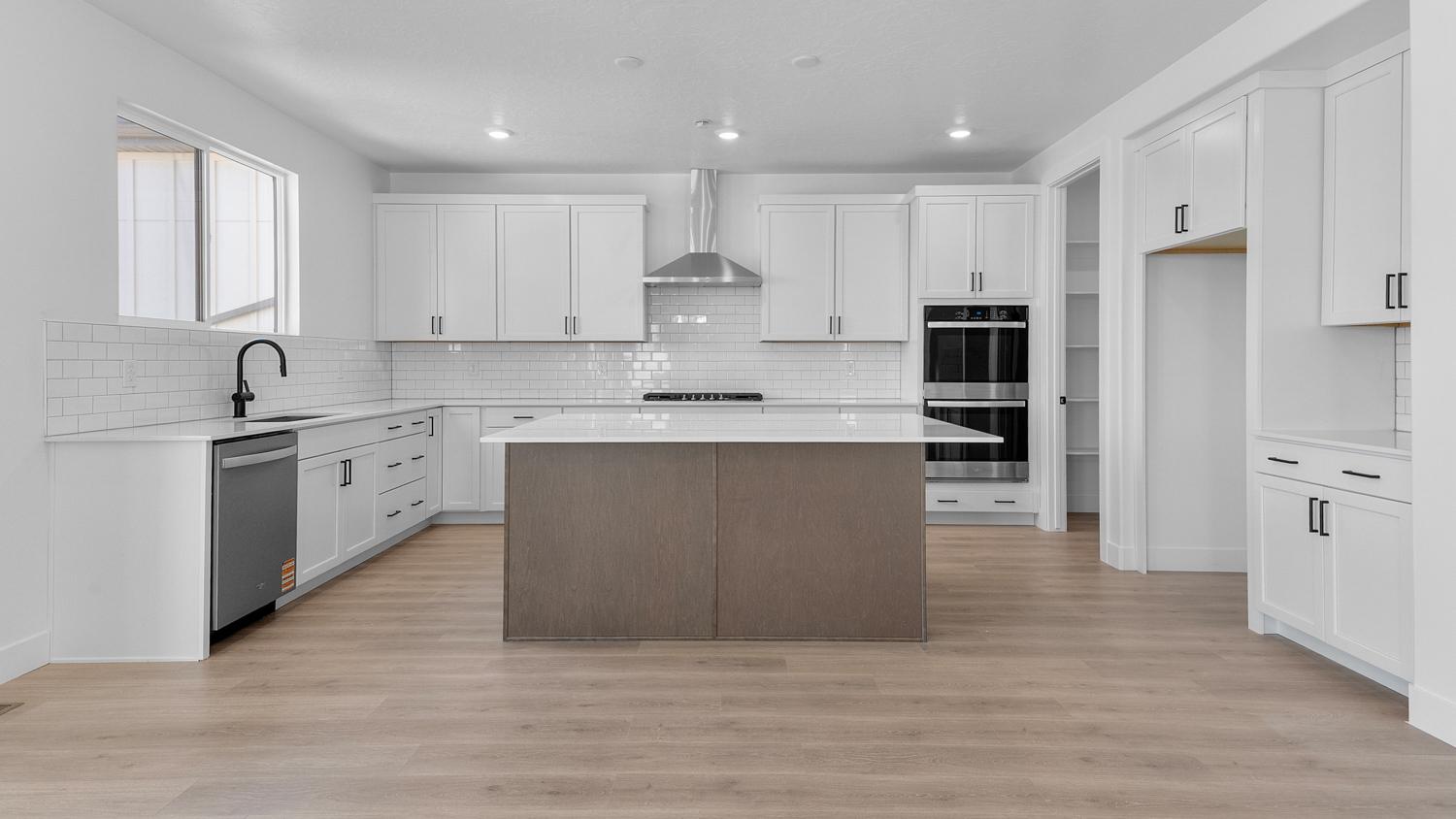 Kitchen space with kitchen island and stainless steel appliances.