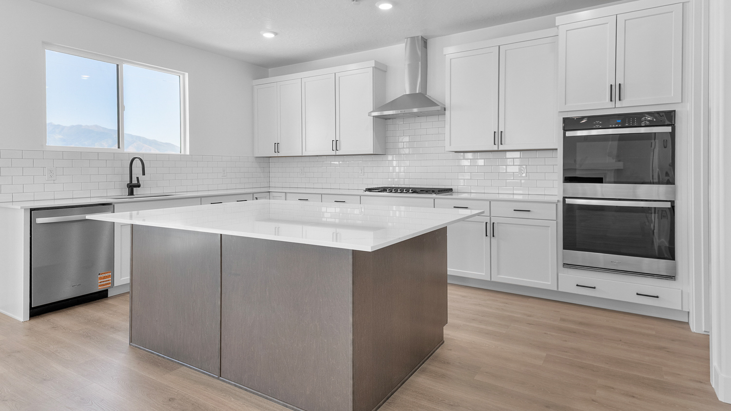 Kitchen space with kitchen island and stainless steel appliances.
