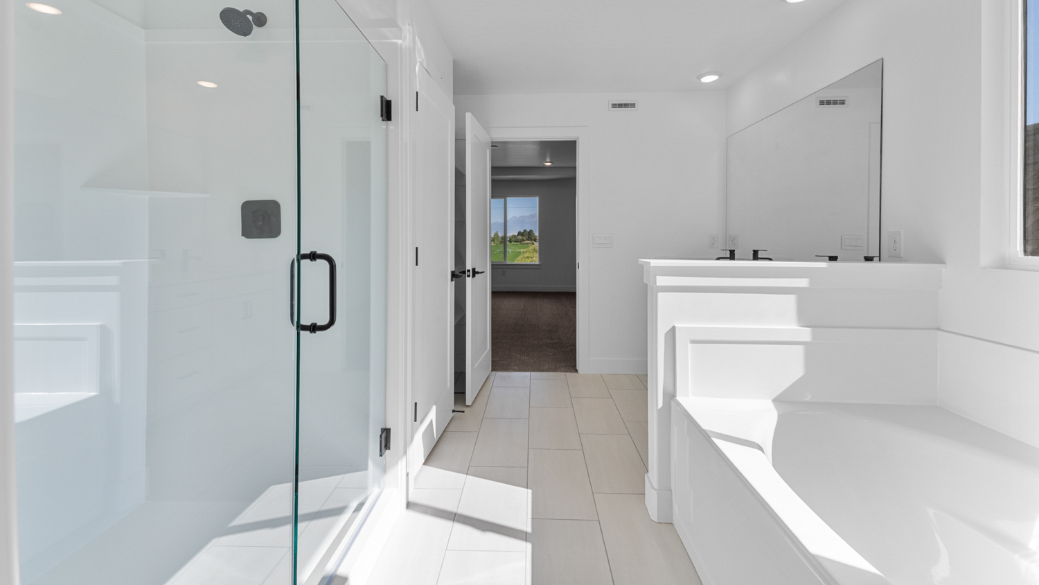 Primary bathroom with glass shower and soaking tub.