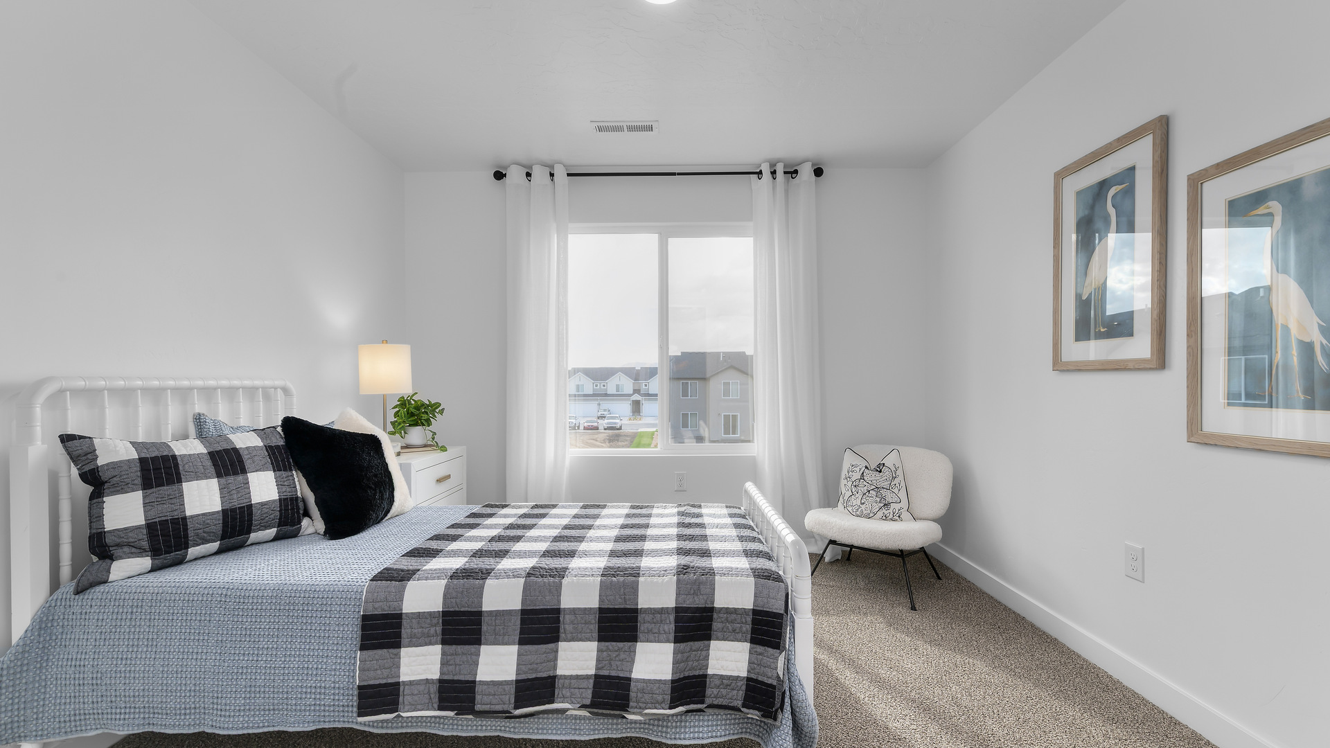 Bedroom with large window and square window in corner.