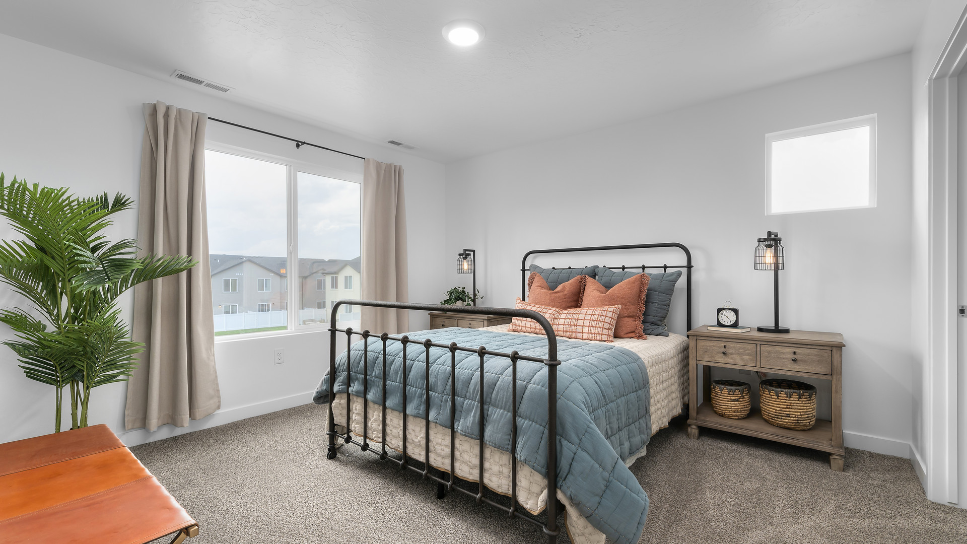 Bedroom with large window and square window in corner.