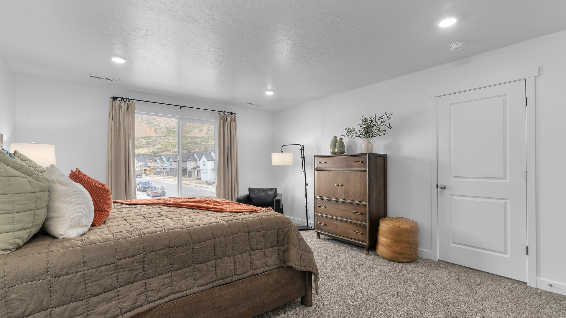 Spacious primary bedroom with a large window and door leading into the en suite full sized bathroom.