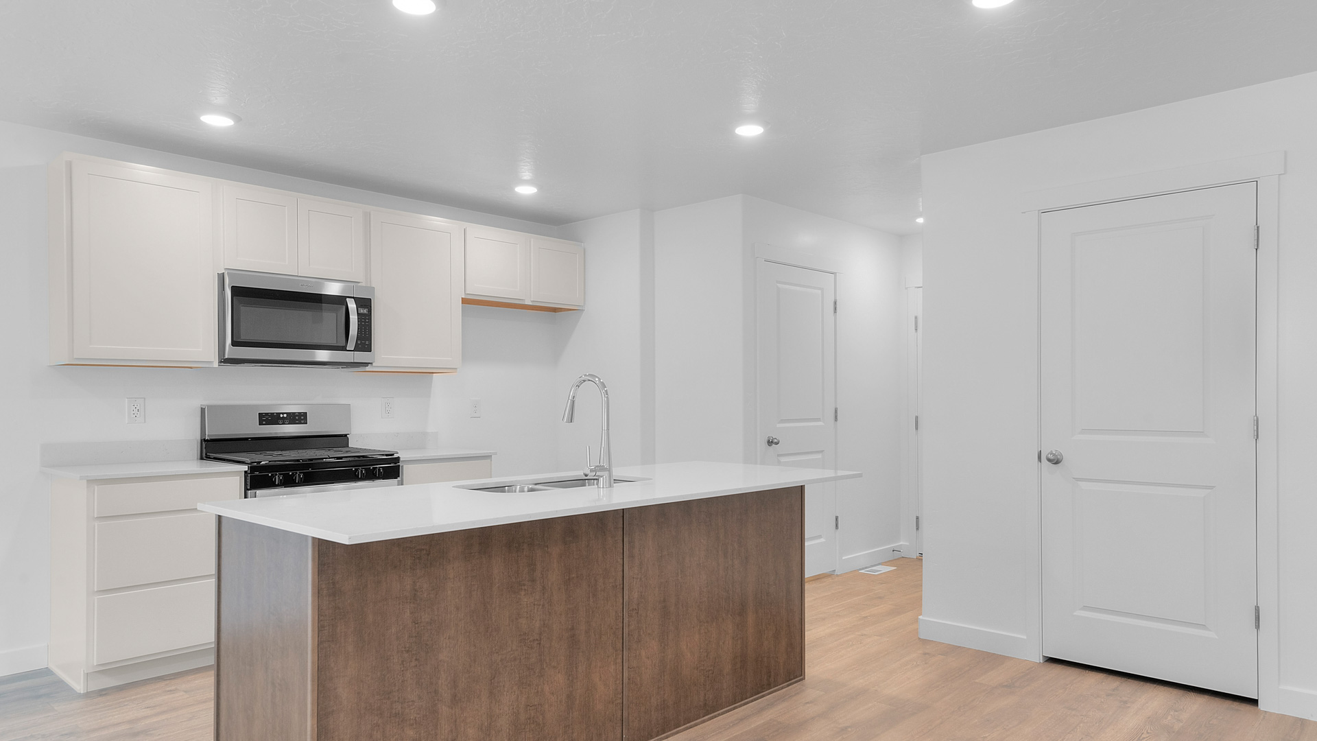 Kitchen space with kitchen island and stainless steel appliances.