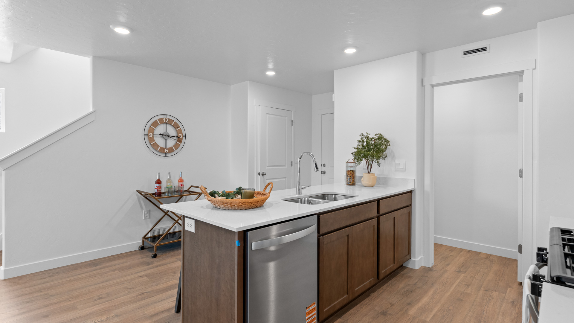 Kitchen space with peninsula featuring barstools, sink, kitchen cabinets, and appliances.