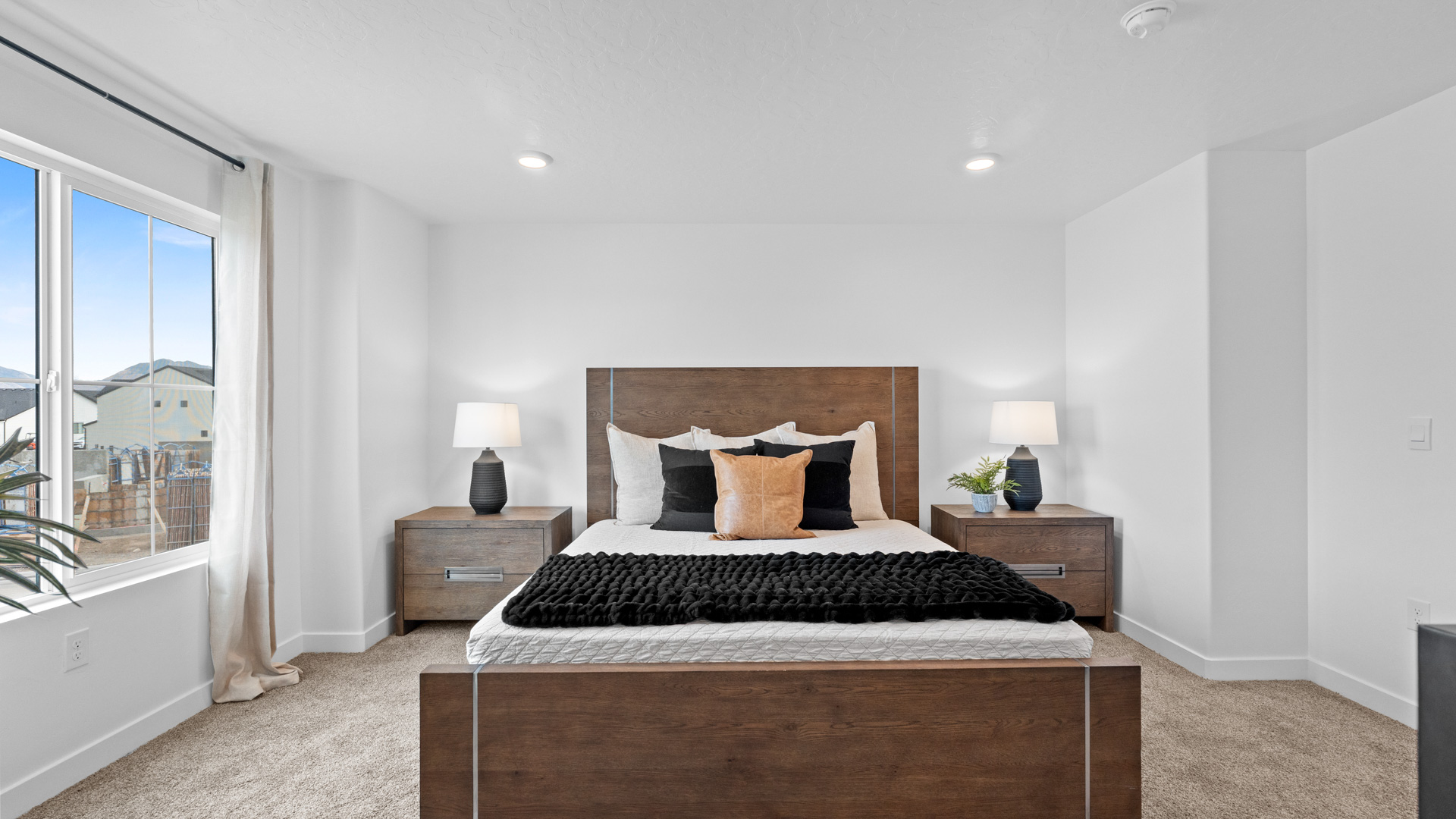 Primary bedroom with large window and beautifully furnished.