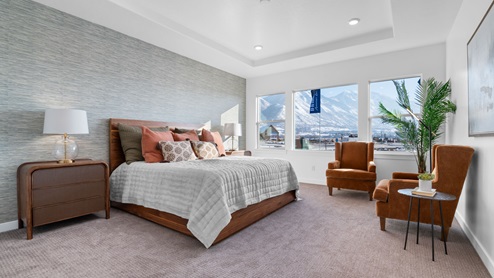 Primary bedroom with tray ceiling, recessed lighting, and large picture window.