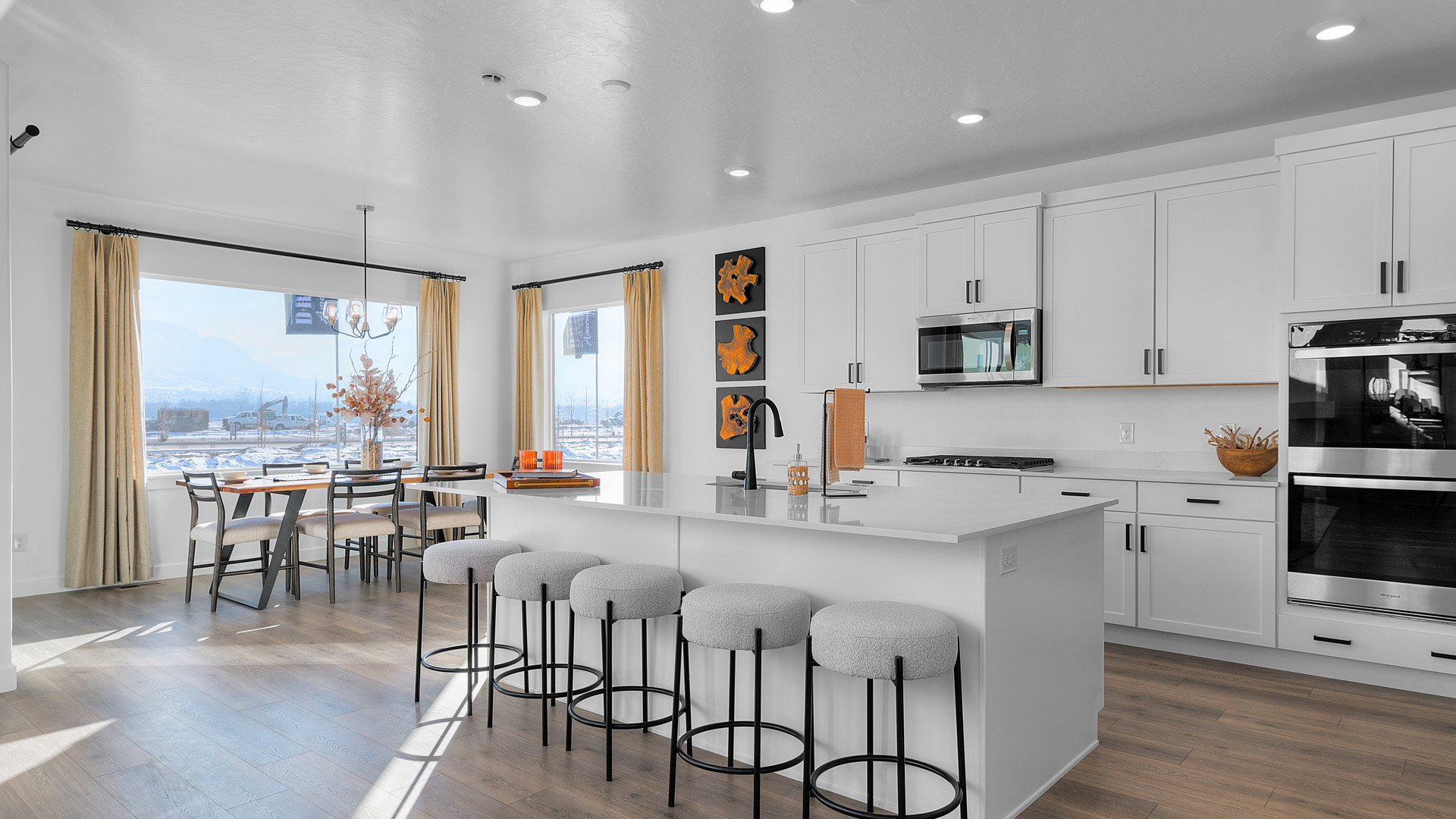 Spacious kitchen with quartz countertops, pendant lighting and stainless steel appliances.